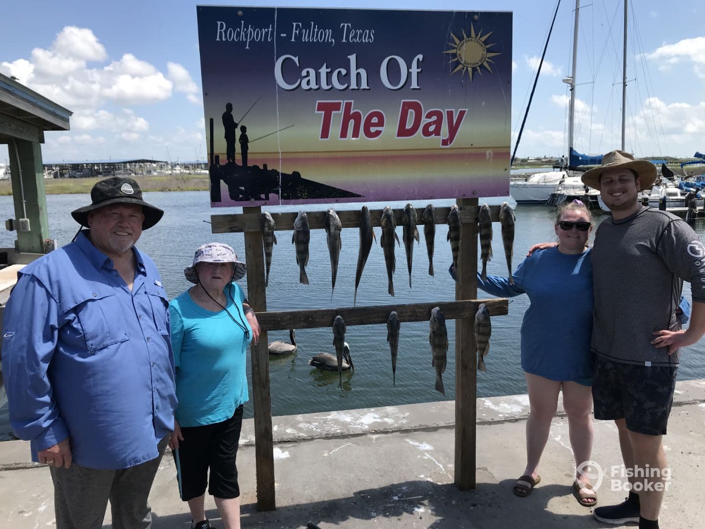 A family poses proudly in front of a catch board displaying their haul of fish at a dock in Rockport, Texas.