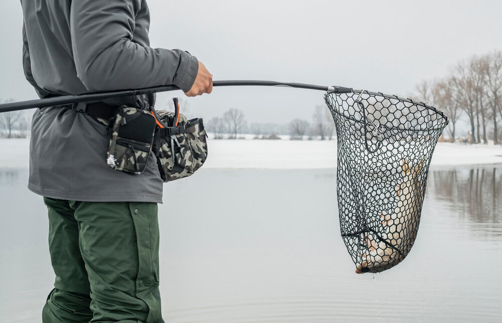 Рыбак с уловом – пойманной зимой щукой